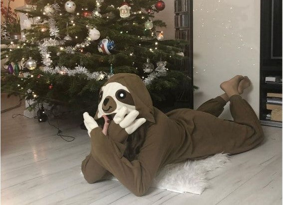 Ein Mensch genießt zu Weihnachten sein warmes Kigurumi-Faultier