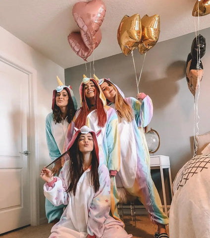 Four girls wearing four Unicorn Kigurumis (two Rainbow, one Pastel Star and one Blue) during a sleepover